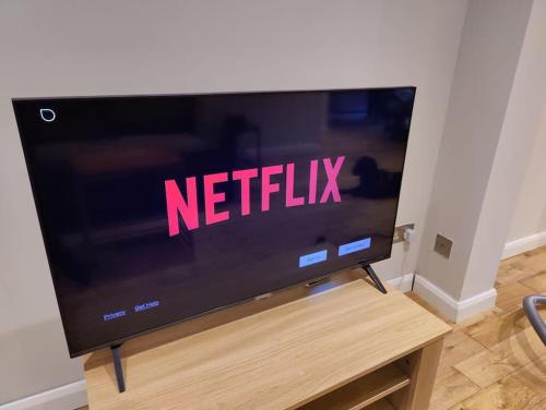 a television screen with the words netflix on it at Kent village house 