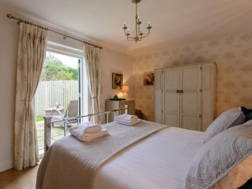 - une chambre avec un lit et une grande fenêtre dans l'établissement 2 Bed in Lulworth Cove DC170, à West Lulworth