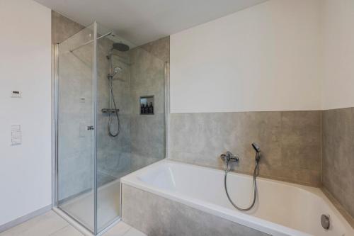 W łazience znajduje się prysznic i wanna. w obiekcie EXQUIS Luxus Apartment USM I Kamin I Terrasse I Parkplatz I Mercedes w mieście Böblingen