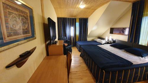 Habitación de hotel con 2 camas y TV en Vila Dubysa en Milašaičiai
