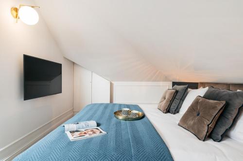 a bedroom with a bed with a tv on it at Central Palace - LoftAffair Collection in Kraków