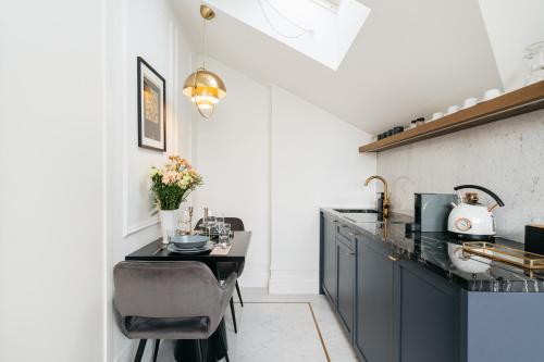 a kitchen with blue cabinets and a black counter top at Central Palace - LoftAffair Collection in Kraków
