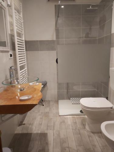 uma casa de banho com um lavatório e um WC em B&B VALCHISONE em Pinasca 