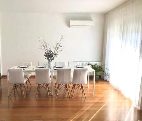 a white dining room with a white table and white chairs at ATHENS RIVIERA Grand Panoramic Villa Lagonissi in Lagonissi