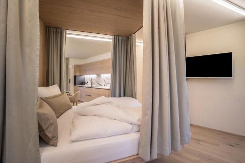a bedroom with a bed with white sheets at Avia Living Teresa in Brunico