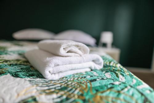 a pile of towels sitting on top of a bed at Apartamenty Poddąbek- basen kryty, sauna, animacje dla dzieci , małpi gaj, baseny na dachu in Poddąbie