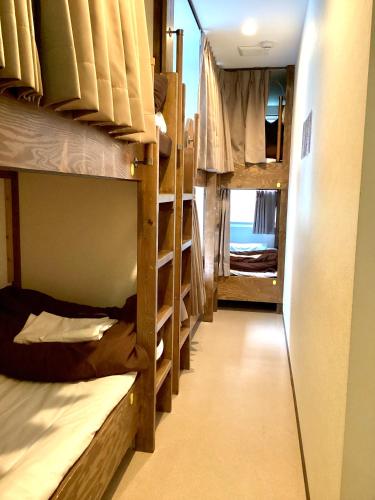 a hallway with several bunk beds in a room at Osaka Namba Hostel MIYABI in Osaka