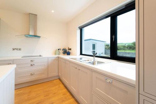 a kitchen with a sink and a large window at Dingle Way Rest ,Luxury holiday home in Dingle