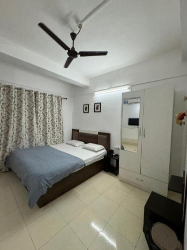 a bedroom with a bed and a ceiling fan at La Belleza Guesthouse in Guwahati
