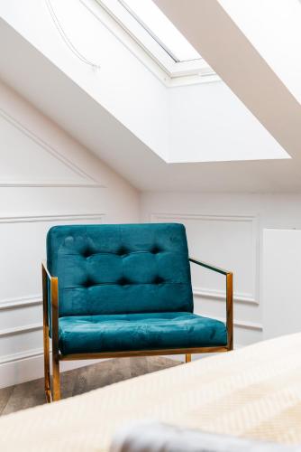 a blue velvet chair in a room with a bed at Central Palace - LoftAffair Collection in Kraków