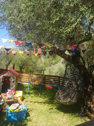 a playground in a yard with a swing at Rania Apartments in Agios Nikitas