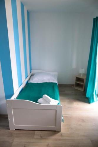 a bed in a room with a green and white at Apartamenty Poddąbek- basen kryty, sauna, animacje dla dzieci , małpi gaj, baseny na dachu in Poddąbie
