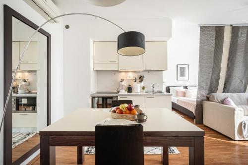 a kitchen and living room with a table with a bowl of fruit at Harmony Hideaway Apartment in Budapest