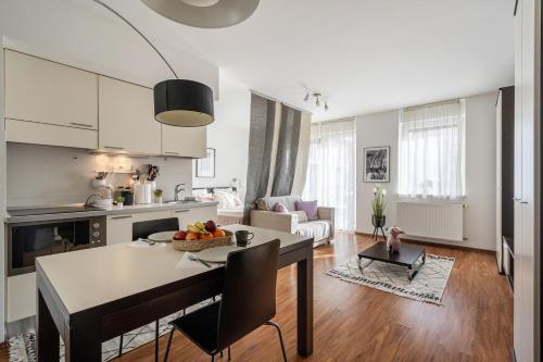 een keuken en een woonkamer met een tafel en stoelen bij Harmony Hideaway Apartment in Boedapest