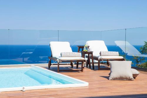 - un groupe de chaises et une piscine sur une terrasse dans l'établissement Esperos Village Blue & Spa - Adults Only, à Faliraki
