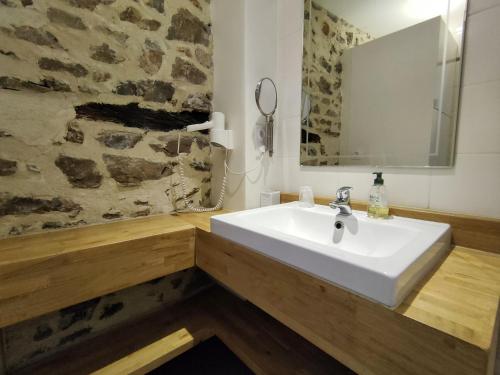 ein Badezimmer mit einem weißen Waschbecken und einem Spiegel in der Unterkunft Le Mas du Martinet in Anduze