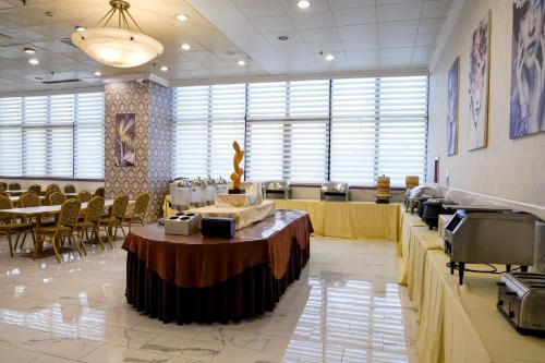 uma sala de jantar com mesa e cadeiras num edifício em Magnificent International Hotel em Xangai