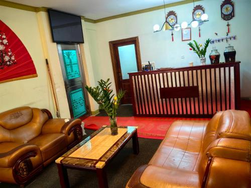阿克拉的住宿－hongyuanprimierhotel，客厅配有皮革家具和桌子
