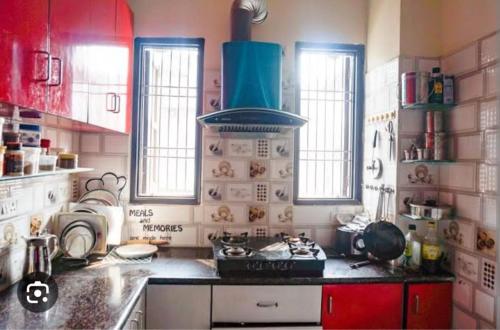 cocina con armarios rojos y fogones en RADHA-NIVAS, en Rohīna