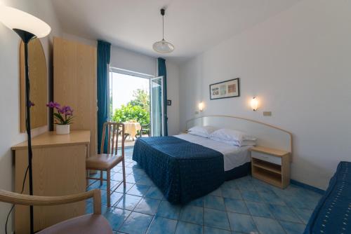 a hotel room with a bed and a window at Hotel Villa Ireos in Ischia