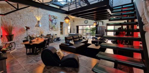 a living room with a staircase and a dining room at Demeure de la Baronne in Vézénobres