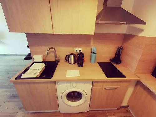 a kitchen with a washing machine on a counter at Appartement charmant parking gratuit in Vaulx-en-Velin