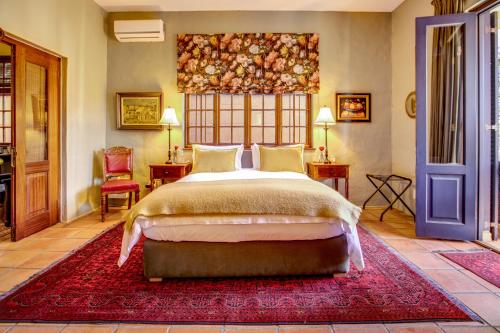 a bedroom with a bed and a red rug at Kensington Views in Cape Town