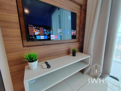 a living room with a tv on a wall at Ipoh Sunway Onsen Suites and Tambun Guesthouse , 3-14pax 2parking by IWH in Ipoh