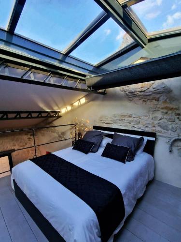 a bedroom with a large bed with a large window at Demeure de la Baronne in Vézénobres