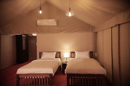 two beds in a tent room with two lamps at Anamala Serenity Homestay Kerala in Lakkidi