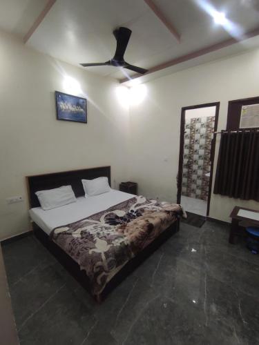 a bedroom with a bed and a ceiling fan at Nidhivan Dhaam in Mathura