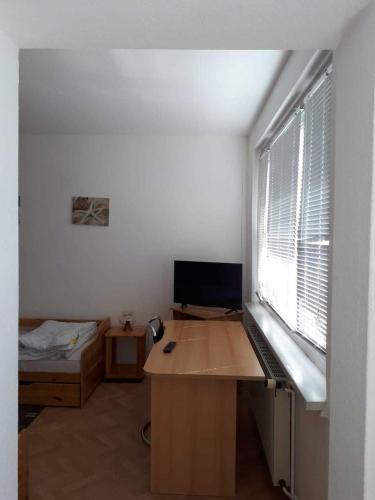 een kamer met een bureau, een computer en een bed bij Nordstraße 5 - Ferienwohnung für 2 Personen in Neukieritzsch in Neukieritzsch