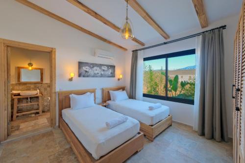 - 2 lits dans une chambre avec fenêtre dans l'établissement Villa Cesur, à Fethiye