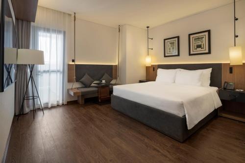 ein Hotelzimmer mit einem großen Bett und einem Sofa in der Unterkunft M Continental by Mandala Bac Giang in Bắc Giang