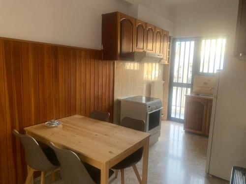 a small kitchen with a wooden table and chairs at Calma apartment in Athens