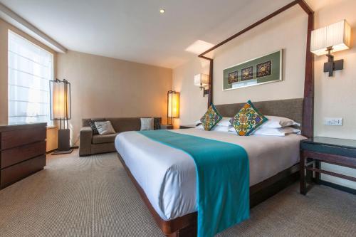 una camera d'albergo con un grande letto e un divano di SSAW Boutique Hotel Hefei Intime Centre a Hefei