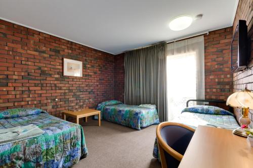 Un pat sau paturi într-o cameră la Enfield Motel