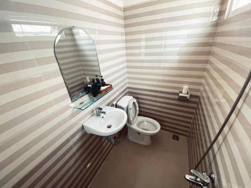 a bathroom with a sink and a toilet and a mirror at Thiên Vương House Đà Lạt in Da Lat
