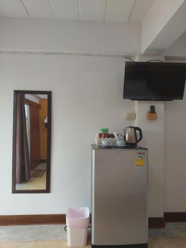 a small refrigerator in a room with a mirror at Ratchawong Place ราชวงศ์ เพลส --หลังพ่อขุน-- in Phayao