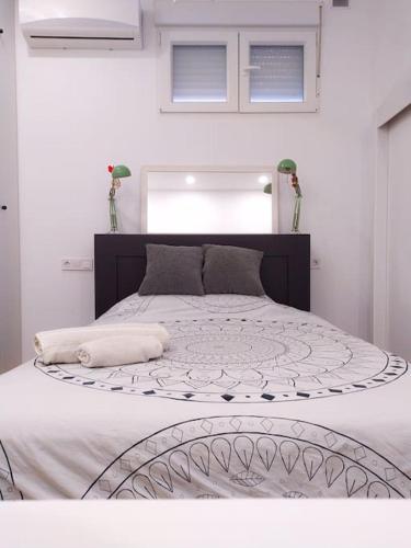 biała sypialnia z dużym łóżkiem z czarnym zagłówkiem w obiekcie Casa con jardín w mieście Almería