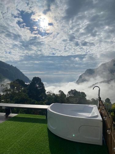 a bath tub sitting on top of a green field at Tham Ma Chard ทำมะชาด in Ban Ko Doi Tung
