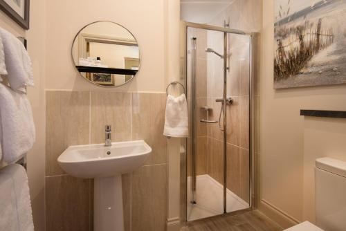 a bathroom with a shower and a sink and a mirror at Bank View in Melrose