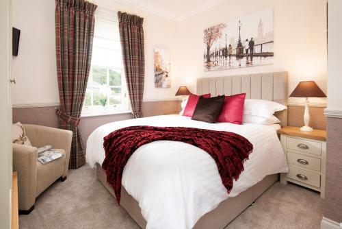 a bedroom with a large bed with red pillows at Bank View in Melrose