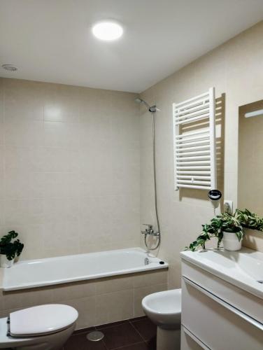 a bathroom with a tub and a toilet and a sink at Piso vacacional acogedor in A Coruña