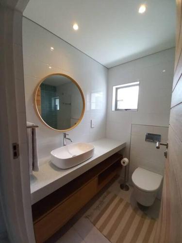 a bathroom with a sink and a toilet and a mirror at Queens Cove One Bedroom Apt 2 in Knysna