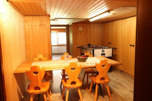 Schlafen im Sternen Ennetbühl في Nesslau: مطبخ مع طاولة وكراسي خشبية