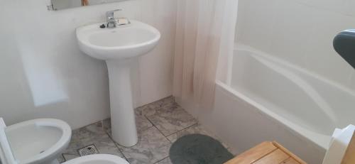 a white bathroom with a sink and a toilet at El portal de san alberto ruta 149 km 10 in Uspallata