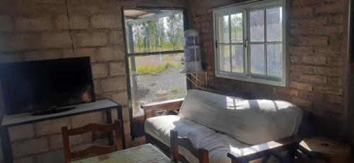 a living room with a couch and a tv and a chair at El portal de san alberto ruta 149 km 10 in Uspallata