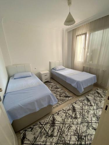 Postel nebo postele na pokoji v ubytování 3Ege Üniversitesine ve Hastane ye çok yakın aile için uygun