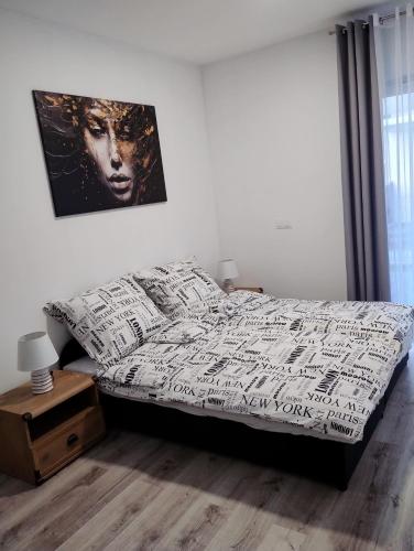 a bedroom with a bed and a picture on the wall at Apartament Sunset Leszno in Leszno